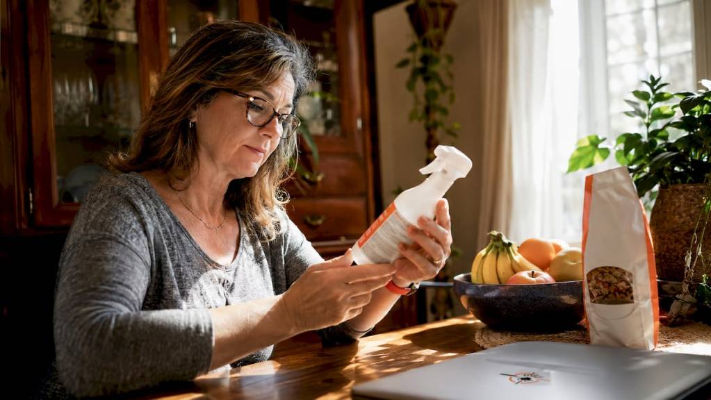 Woman checking pet safe pest treatment in kitchen
