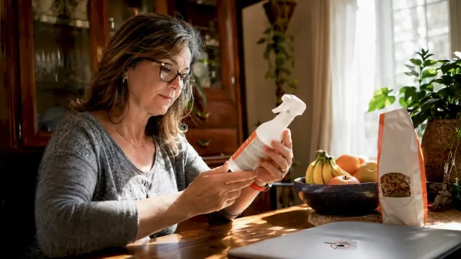 Woman checking pet safe pest treatment in kitchen